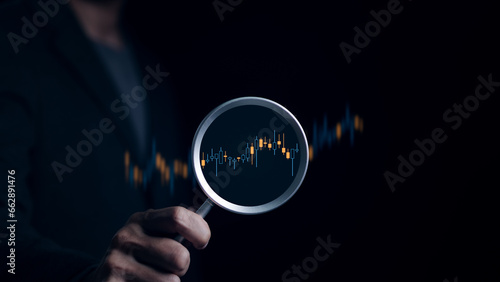 Stock investment concept. Businessman hand holding magnifying glass with virtual stock market chart, Currency exchange trade, Graph analysis technical, Business growth, Economic report, Money wealth,