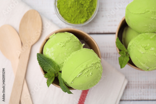Paper cups with tasty matcha ice cream on white wooden table, flat lay