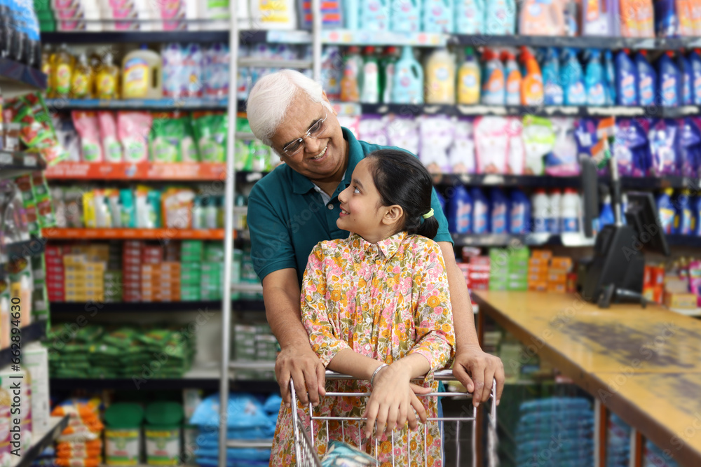 Happy Grandpa and Granddaughter enjoying purchasing in a grocery store. Buying grocery for home in a supermarket.