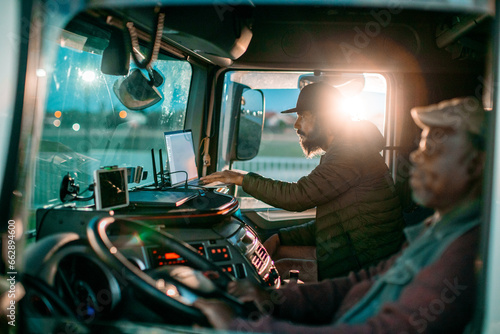 Two diverse truck drivers working together while on the road photo