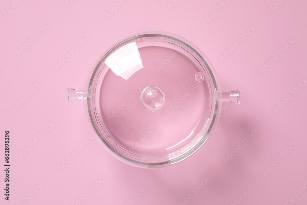 Glass pot with lid on pink background, top view Glass pot with lid on pink background, top view