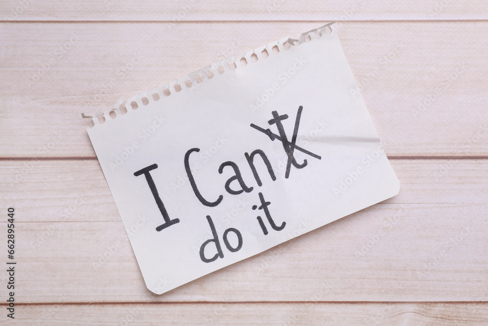 Motivation concept. Changing phrase from I Can't Do It into I Can Do It by crossing out letter T on light wooden table, top view Motivation concept. Changing phrase from I Can't Do It into I Can Do It by crossing out letter T on light wooden table, top view