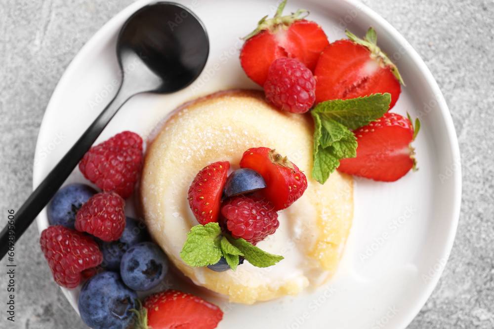 Delicious vanilla fondant served with fresh berries on grey textured table, top view Delicious vanilla fondant served with fresh berries on grey textured table, top view