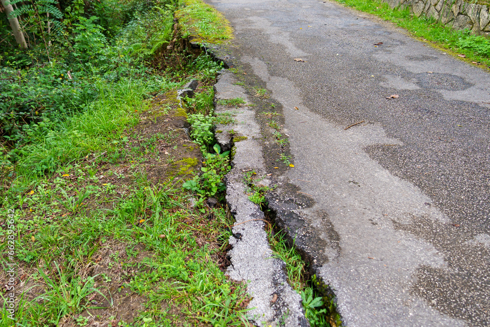 Collapsed broken asphalt road in the forest due to an earthquake