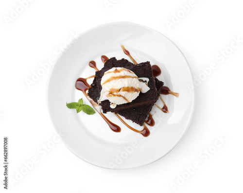 Tasty brownies with ice cream, mint and caramel sauce isolated on white, top view