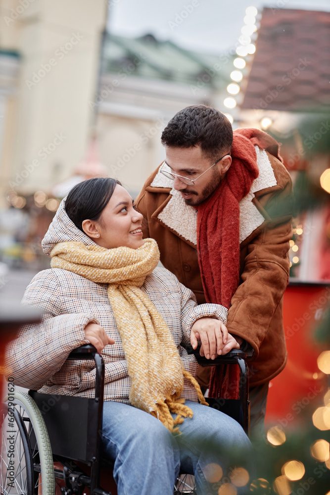 Vertical portrait of romantic young couple with disability enjoying date together outdoors and looking at each other Vertical portrait of romantic young couple with disability enjoying date together outdoors and looking at each other