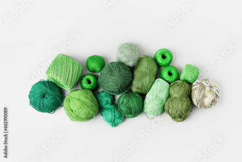 Green knitting threads of different shades on a gray background. Pattern of balls of thread. Concept needlework. Flat lay