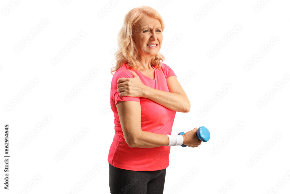 Mature woman in sportswear with painful shoulder holding a dumbbell Mature woman in sportswear with painful shoulder holding a dumbbell