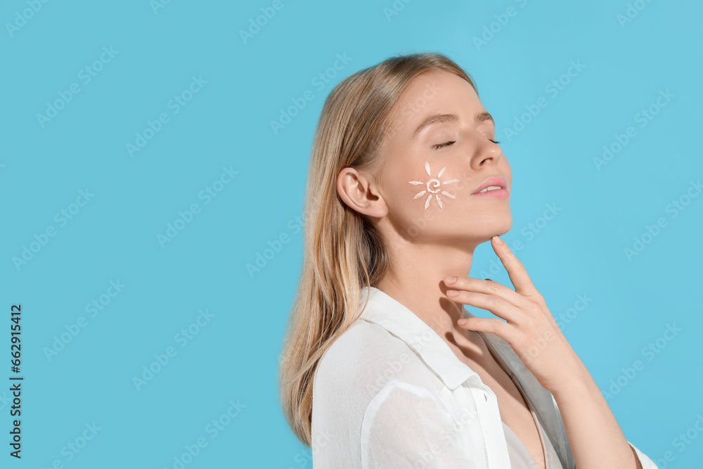 Beautiful young woman with sun protection cream on her face against light blue background, space for text Beautiful young woman with sun protection cream on her face against light blue background, space for text