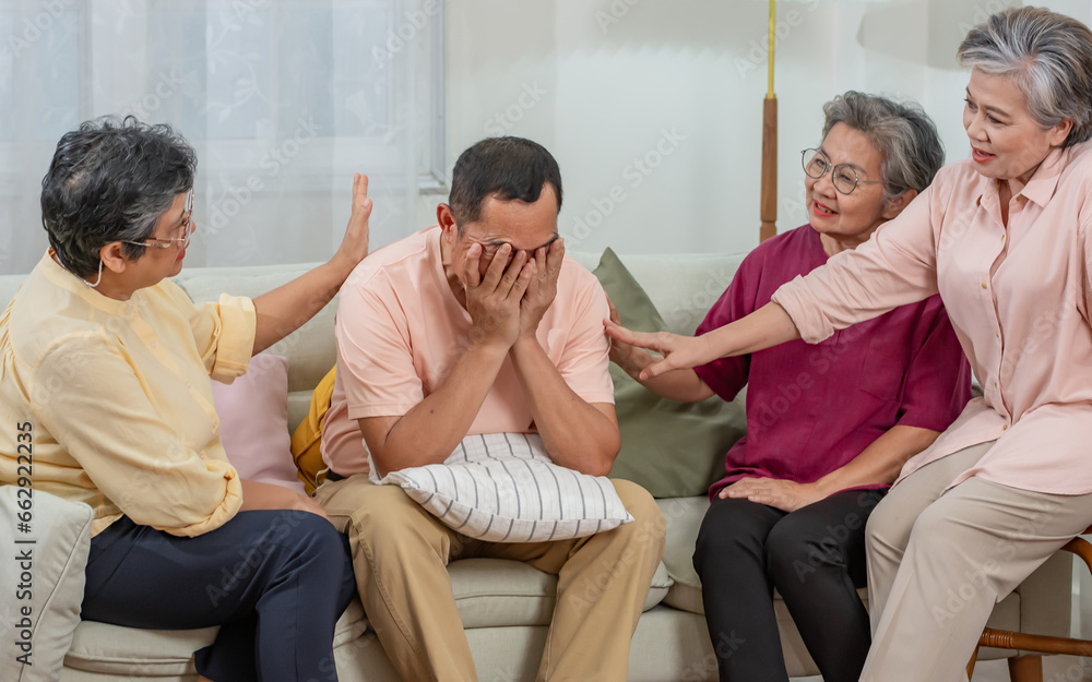 Obraz premium Group mixed genders senior Asian aging female sitting on sofa in cozy nursing home, encourage friend who get diseases, depression. Retirement, Healthcare, Aging Society Concept.