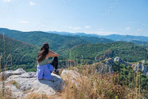 Woman standing in the summer mountain with stunning view 
