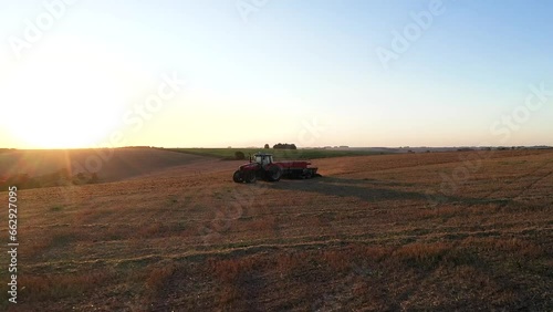 Tractor working in the field with a seeder.