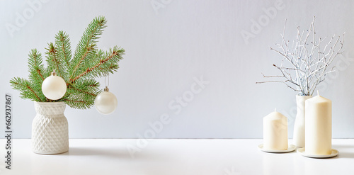 Christmas, New Year home decor. Empty white wall mock up with green fir branches in a vase on a white table. Mock up for displaying works photo