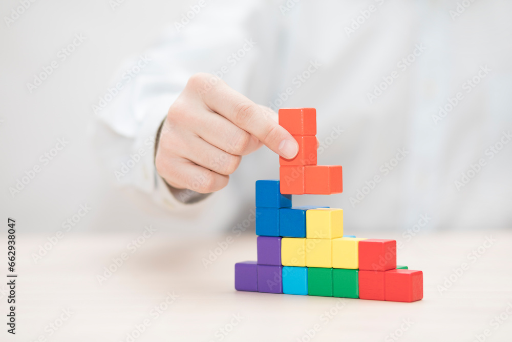 Man's hand stacking colorful wooden blocks. Business development concept Man's hand stacking colorful wooden blocks. Business development concept