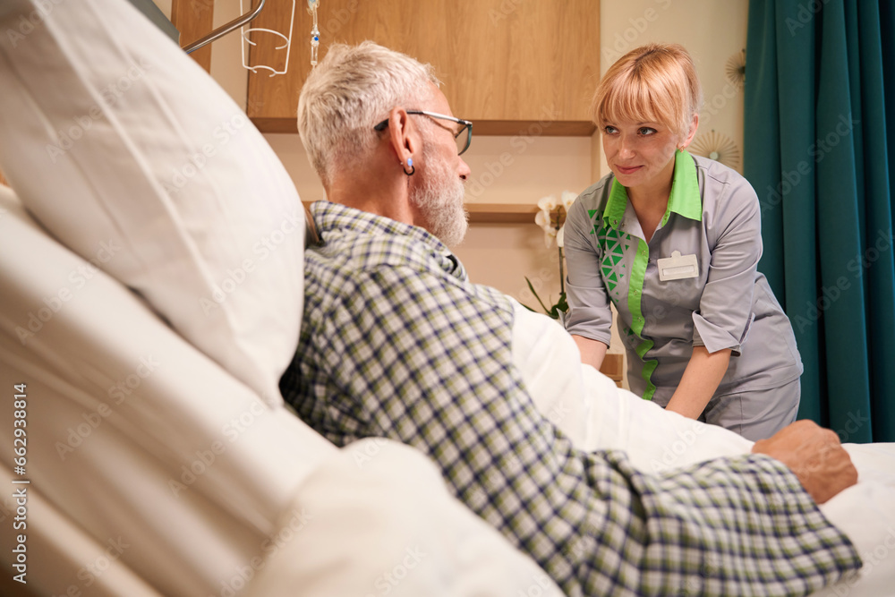 Blonde nurse gives an injection into vein of elderly man Blonde nurse gives an injection into vein of elderly man