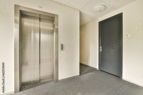 an empty office with two elevators in the middle and one on the other side, taken from above to the floor