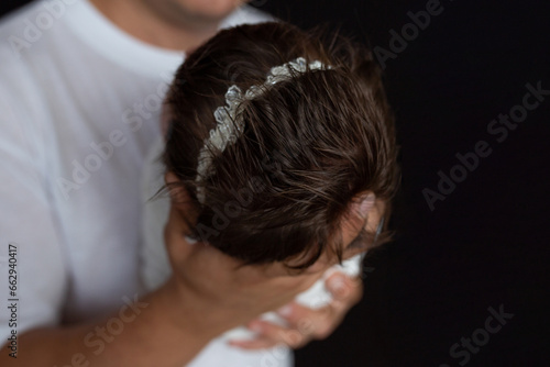 Head of a newborn baby in father's arms