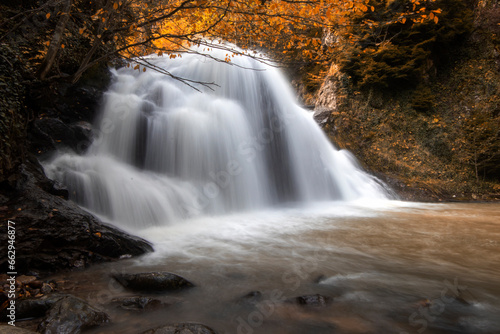Autumn landscape with waterfall and rocks in the forest  long exposure