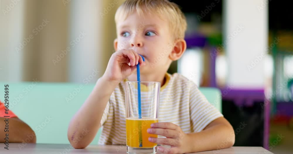 Cute children drinking soda or soft drink with straw in a fast food restaurant Cute children drinking soda or soft drink with straw in a fast food restaurant