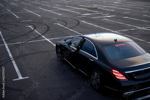 Luxury black car on a parking lot, view from above. Business transfer serfice concept and transportation concept