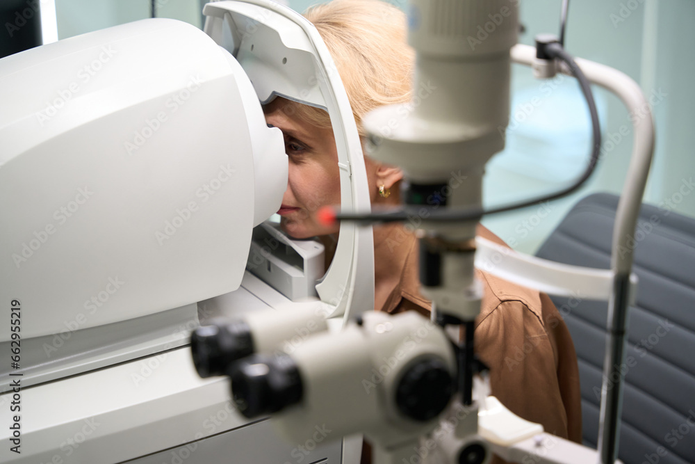 Elegant woman sits in front of a special ophthalmic device