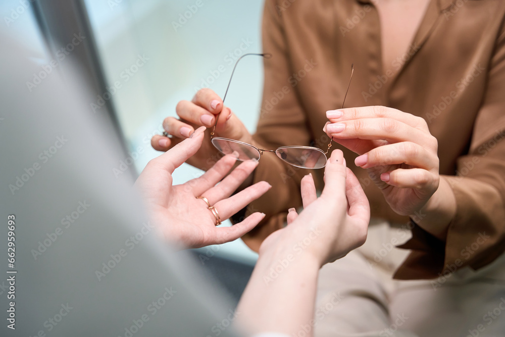 Fototapeta premium Young doctor gives glasses to a lady