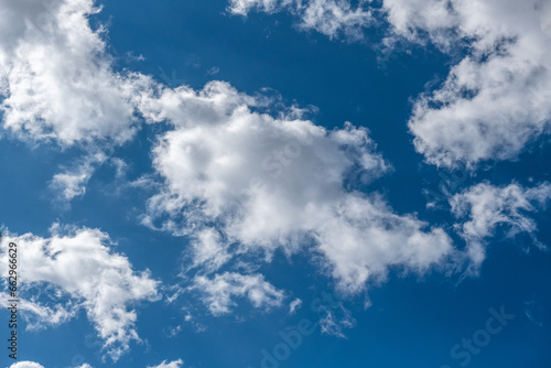 białe, nieregularne chmury na błękitnym niebie photo