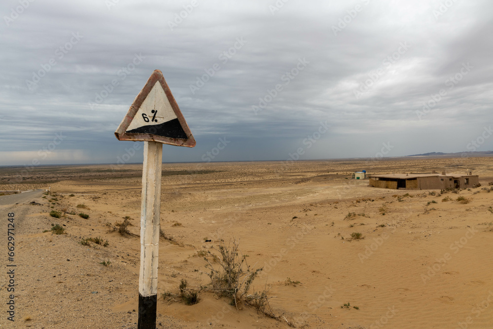 Usbekistan: Wüstenfestung Ayaz quala mit Verkehrsschild im Vordergrund - obrazy, fototapety, plakaty 