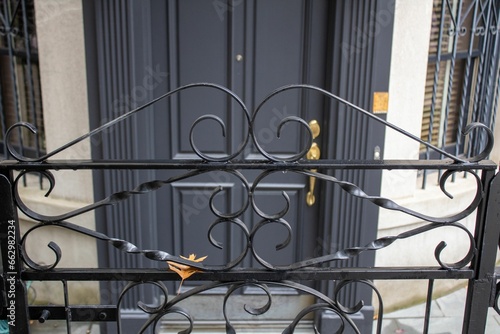 the black iron gate of a building and some yellow scissors