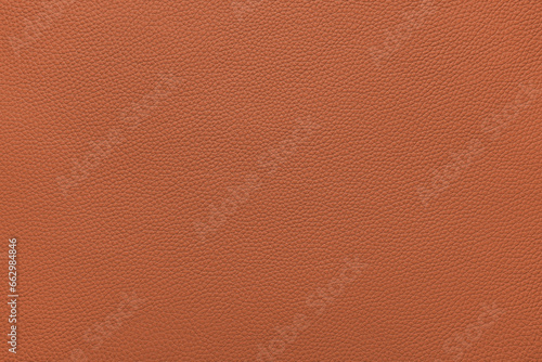 Genuine orange leather, eco friendly leatherette texture background. Material for upholstery and interior design, sport items and clothes. Wallpaper, banner, backdrop. photo