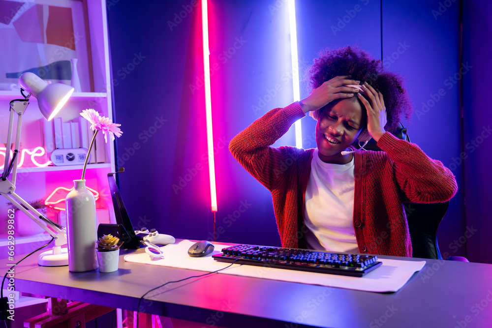Φωτογραφία African American girl streamer playing online fighting with Esport skilled team wearing headphones in neon color lighting room