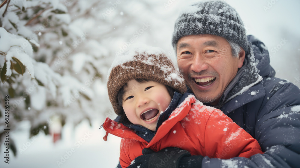 Portrait of happy asian father and child in snow.