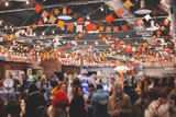 Crowded Christmas market with New Year decorations and multicolored flags, balloons, garlands and festoons, indoor Xmas fair interior, retail kiosk and store with illumination and gifts for sale
