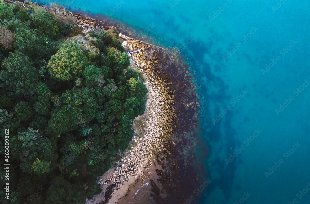 A drone shot of a rocky cove by the deep blue sea