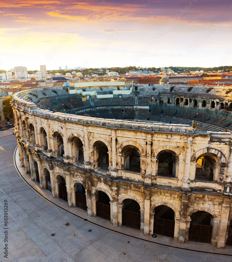 Aerial view of Roman amphitheatre on background with cityscape of Nimes, France