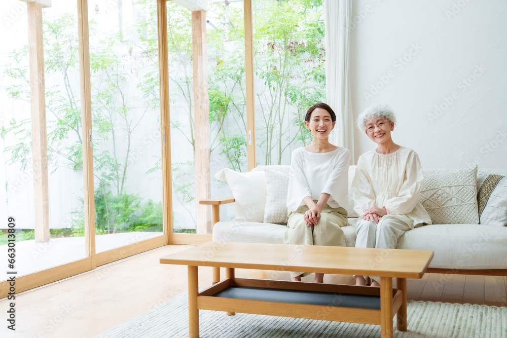 リビングでリラックスする母と娘のポートレート リビングでリラックスする母と娘のポートレート