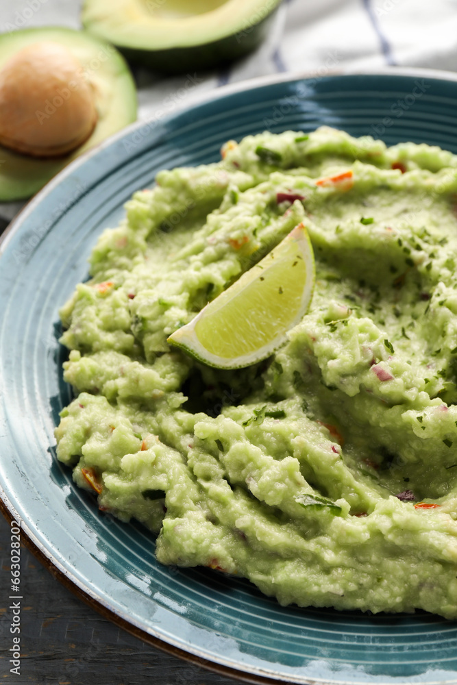 Delicious guacamole with lime on table, closeup Delicious guacamole with lime on table, closeup