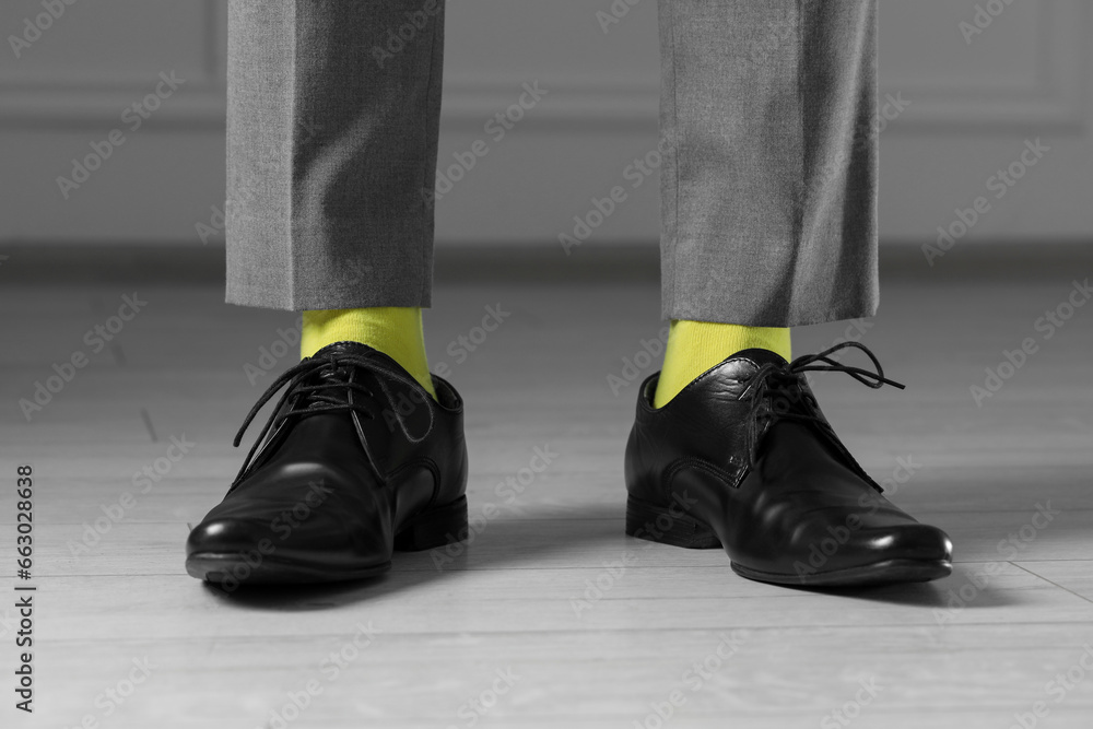 Man wearing stylish shoes and yellow socks indoors, closeup Man wearing stylish shoes and yellow socks indoors, closeup