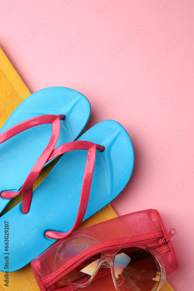 Light blue flip flops, sunglasses and case on pink background, top view with space for text. Beach accessories Light blue flip flops, sunglasses and case on pink background, top view with space for text. Beach accessories