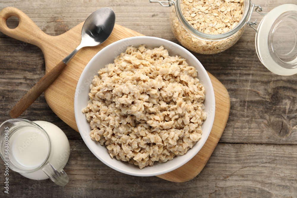Tasty boiled oatmeal served on wooden table, flat lay Tasty boiled oatmeal served on wooden table, flat lay