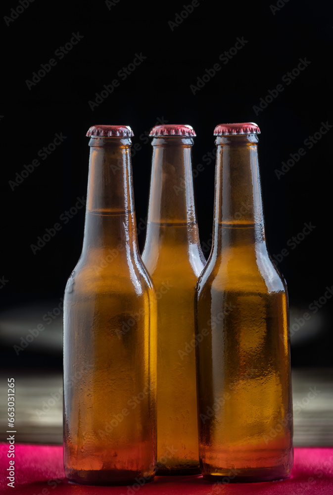 Cold beer bottles on wooden table with selective focu