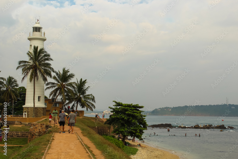 Lighthouse in Galle fort, Sri Lanka. Indian ocean shore, palms, Sri Lanka.