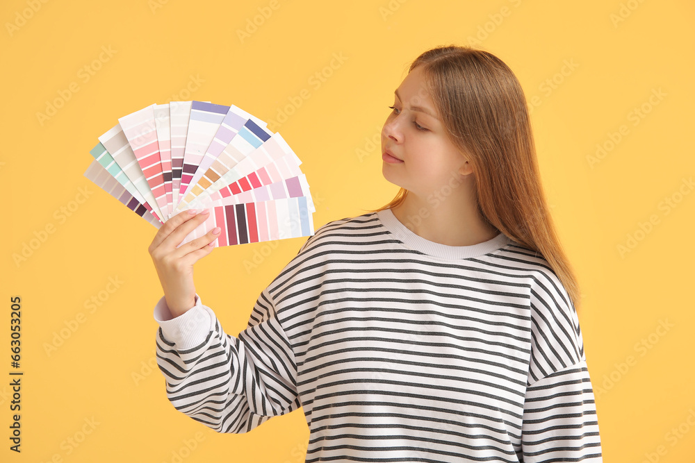 Young woman with many color samples on yellow background Young woman with many color samples on yellow background