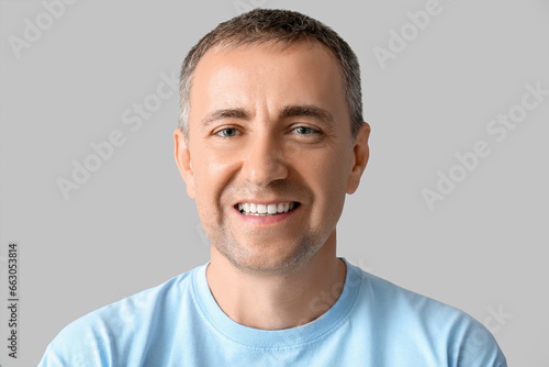 Portrait of happy mature man on grey background