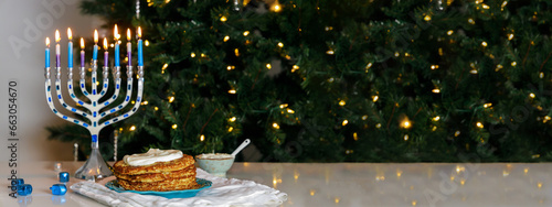 Jewish holiday dinner with a menorah and crispy potato latkes.