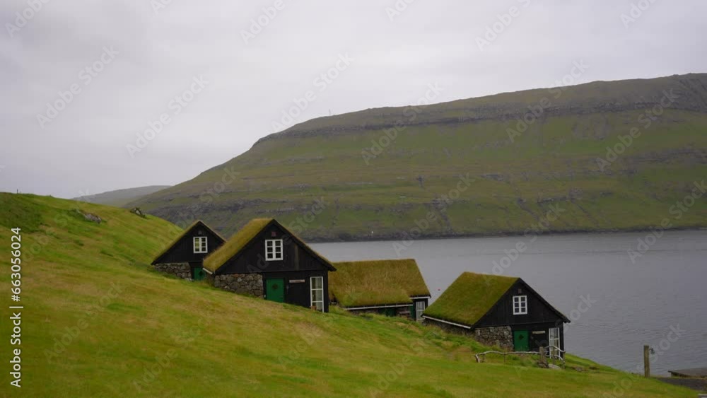 Typical wooden houses with grass roofs on the coast of Vagar in Faroe Islands. pan right Typical wooden houses with grass roofs on the coast of Vagar in Faroe Islands. pan right