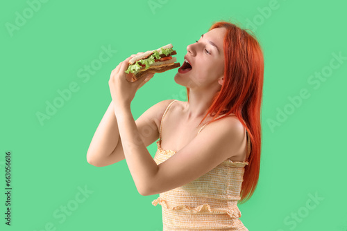 Young redhead woman eating ...