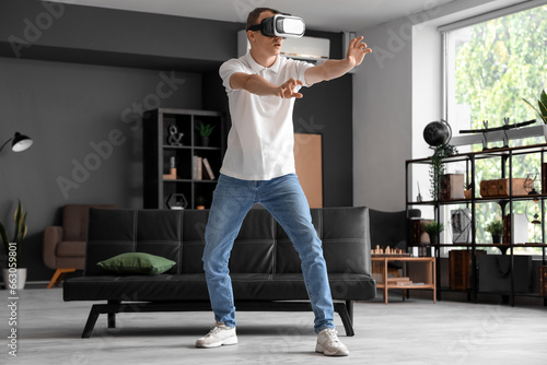 Young man using VR glasses ...
