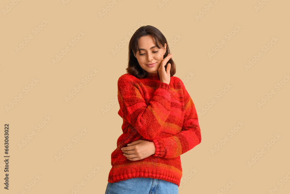 Young woman in red sweater on beige background Young woman in red sweater on beige background