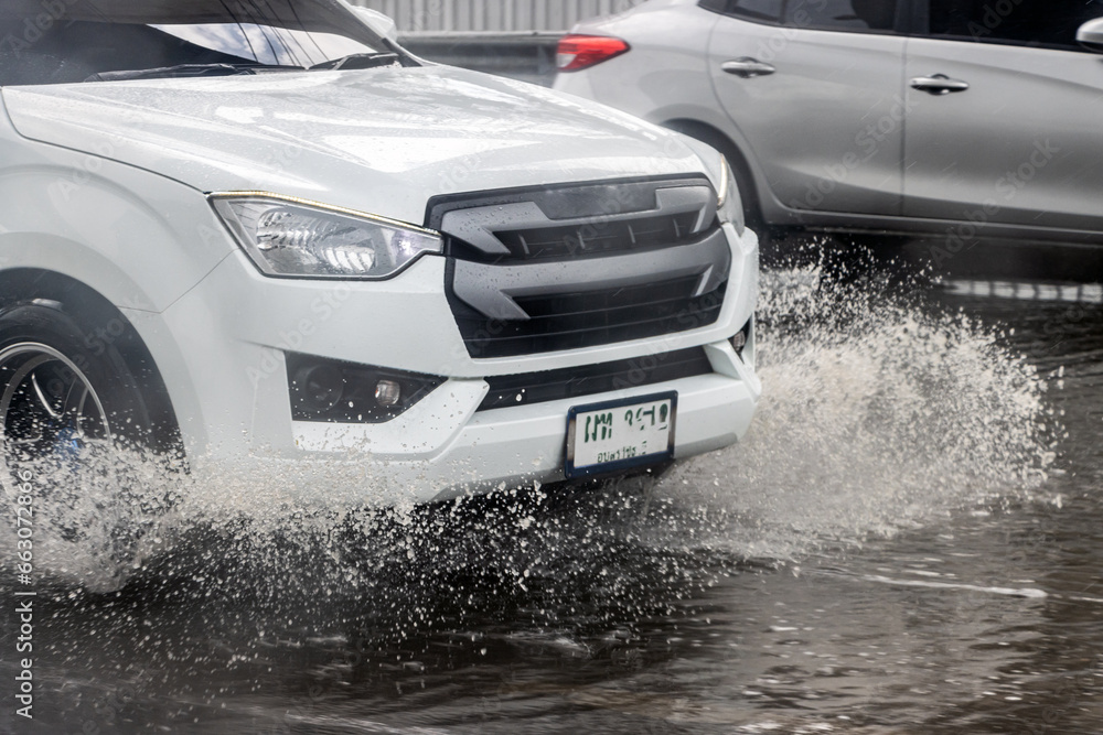 Cars drive through a puddle on the highway in the rain Cars drive through a puddle on the highway in the rain